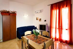 uma sala de estar com uma mesa e um sofá azul em Case Vacanza Le Magnolie em Castellammare del Golfo