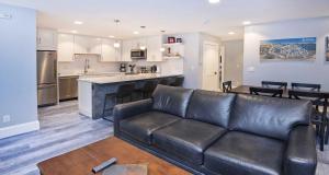 a living room with a leather couch and a kitchen at Scorpio #104 Condo in Vail