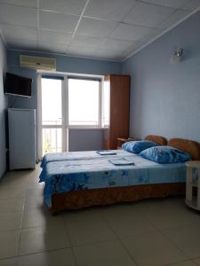 1 dormitorio con 1 cama grande y paredes azules en Дом На Хвойной, en Lazarevskoye