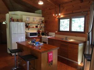 a kitchen with a white refrigerator and a stove at Sea Nest in Batemans Bay