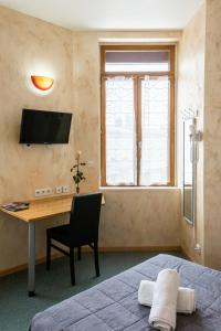 a bedroom with a bed and a desk at Hôtel de la Gare in Latresne
