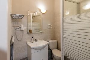 a bathroom with a toilet a sink and a shower at Hôtel de la Gare in Latresne