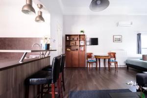Il comprend une cuisine et un salon avec une table et des chaises. dans l'établissement Andrassy Garden Apartment in Center, à Budapest