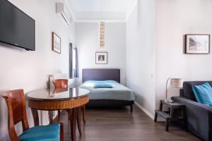 ブダペストにあるAndrassy Garden Apartment in Centerのベッド、テーブル、ソファが備わる小さな客室です。
