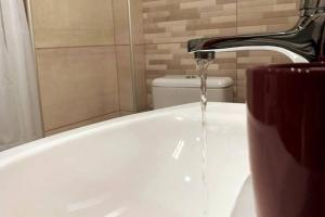 a bath tub with a water faucet in a bathroom at Helen`s Luxury Apartment in Heraklio Town