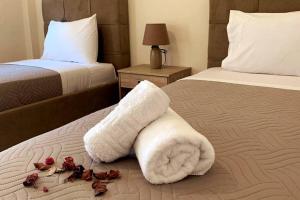 une chambre d'hôtel avec deux lits avec des serviettes sur le lit dans l'établissement Helen`s Luxury Apartment, à Héraklion