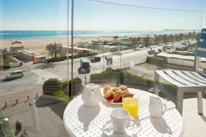 a table with a plate of food and a view of the beach at Hotel Ambassador in Rimini