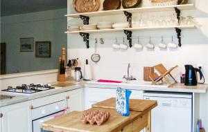 a kitchen with white cabinets and a stove top oven at Gorgeous Home In Scillé With Wifi in Scillé