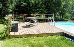 una terraza de madera con mesa y sillas junto a una piscina en Pet Friendly Home In Scill With Heated Swimming Pool, en Scillé