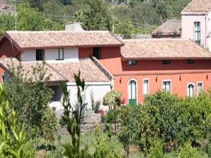 un groupe de maisons sur une colline plantée d'arbres dans l'établissement Baglio Delle Rose, à Giarre