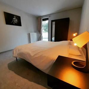 - une chambre avec un lit et une table avec une lampe dans l'établissement Le gîte du Verger, à Villers-devant-Orval