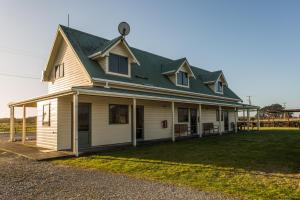 a large white house with a green roof at Haast Beach Motel in Haast