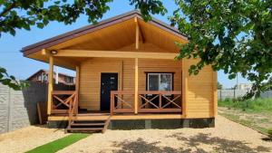 a small yellow building with a porch and a door at Новый дом целиком 800м от моря за городом в тихом уютном месте in Chornomorsk