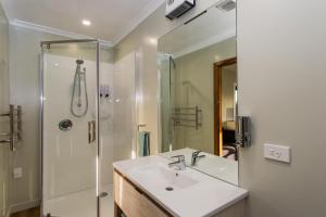 een badkamer met een wastafel en een douche bij Haast Beach Motel in Haast