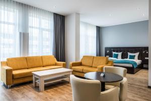 un soggiorno con divano e letto di RheinCity Hotel & Boardinghouse a Ludwigshafen am Rhein