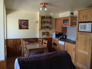 a kitchen with wooden cabinets and a table and a microwave at Appartement Valloire, 2 pièces, 5 personnes - FR-1-263-456 in Valloire
