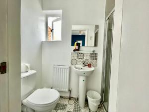 a white bathroom with a toilet and a sink at The Corner House - Modern Chesterfield Town Centre Apartments in Chesterfield +37 photos