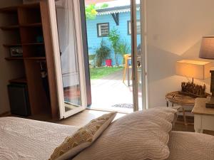 a bedroom with a bed and a sliding glass door at Maison d'hôtes Côté Lagon in Saint-Pierre
