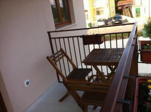 Un balcón con una silla de madera y una mesa. en Solaria Apartments Porec, en Poreč