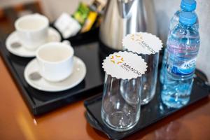 ein Tablett mit zwei Flaschen Wasser und Tassen in der Unterkunft Manor Hotel in Taschkent