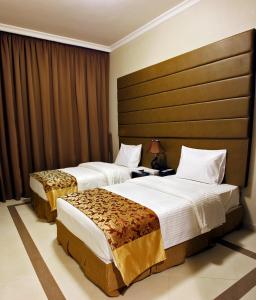 a hotel room with two beds and a headboard at Paragon Hotel Apartments in Abu Dhabi +35 photos