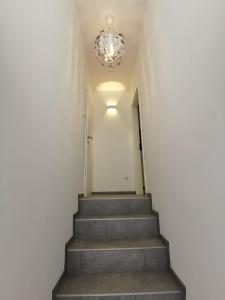 a hallway with stairs and a chandelier at Zum Hofgassl Haus Flo in Mörbisch am See