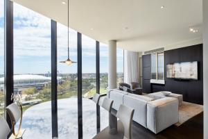 a living room with a large glass wall at Eos by SkyCity in Adelaide