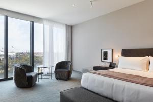 a hotel room with a large bed and a large window at Eos by SkyCity in Adelaide