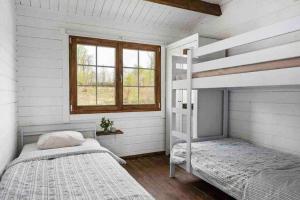 a bedroom with two bunk beds and a window at Cozy Cottage near lake in Hässleholm