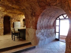 a kitchen in a stone building with a table and chairs at Underwood Court fresh Dugout- Hosted by Coober Pedy Accommodations in Coober Pedy