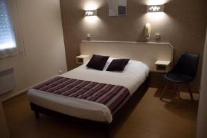 ein Hotelzimmer mit einem Bett und einem Stuhl in der Unterkunft Rev'hotel in Ribérac