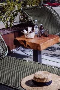 a rattan table with glasses and a hat on a table at Le Garage Biarritz Hôtel in Biarritz
