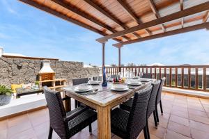 a wooden table and chairs on a patio at Lanzarote Villa Vista Lobos 47 in Playa Blanca