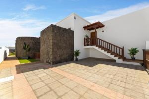 a house with a stone wall and a staircase at Lanzarote Villa Vista Lobos 47 in Playa Blanca