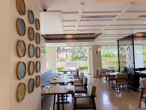 a dining room with tables and chairs and clocks on the wall at Holiday Inn Goa Candolim in Candolim