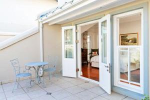 a patio with a table and chairs and a bedroom at Isola Bella Guest House in Knysna