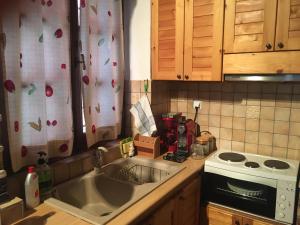 a kitchen with a sink and a stove at Red Villa's Guesthouse in Tsagarada