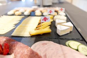 a bunch of cheese and other foods on a table at JUFA Hotel Hochrindl in Hochrindl +69 photos