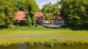 an aerial view of a large house on a river at Emsland Hotel Saller See in Freren