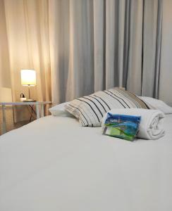 Una cama blanca con una almohada y una toalla. en Motel lavapies, en Madrid