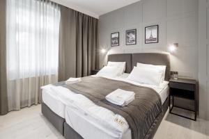a bedroom with a large bed with two towels on it at Apartamenty L11, Limanowskiego in Poznań