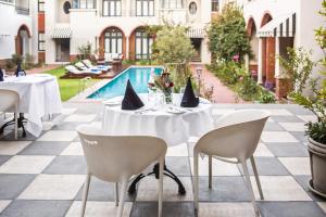 einen Tisch und Stühle auf einer Terrasse mit Pool in der Unterkunft The Winston Hotel in Johannesburg