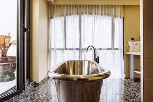 La salle de bains est pourvue d'un lavabo en face d'une fenêtre. dans l'établissement Le Garage Biarritz Hôtel, à Biarritz