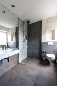 a bathroom with a shower and a sink and a toilet at Bergwirt Hotel & Gasthof in Kiefersfelden