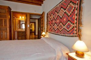 a bedroom with a bed and a rug on the wall at Cortijo Prado Toro in Pitres +51 photos