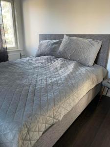 a bed with a white comforter in a bedroom at Torggatan 54 in Mariehamn