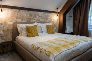 Un dormitorio con una cama grande con almohadas amarillas y blancas en 103 Alpine Hotel, en Panichishte