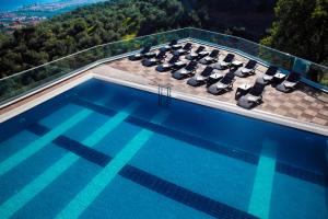 a swimming pool with lounge chairs on top of a building at Rezone Health & Oxygen Hotel Kazdağları in Altınoluk