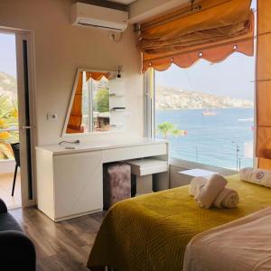 a bedroom with a desk and a bed with a window at Hotel Ramo Saranda in Sarandë