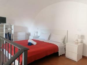 ein Schlafzimmer mit einem Bett mit einer roten Decke in der Unterkunft Casetta Russo in Meta